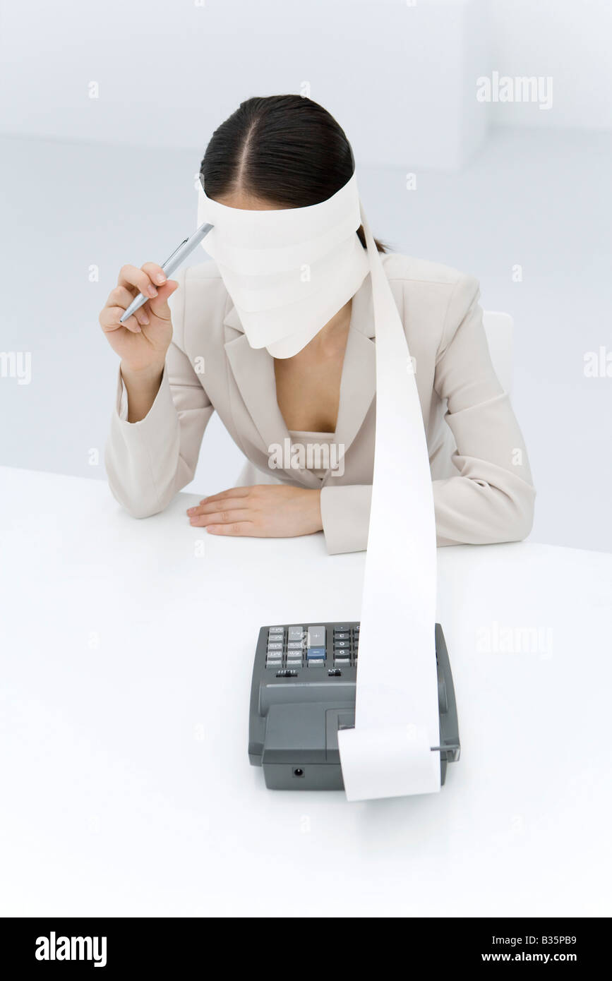 Woman Using A Adding Machine Woman sitting with adding machine tape wrapped around head, holding pen ...