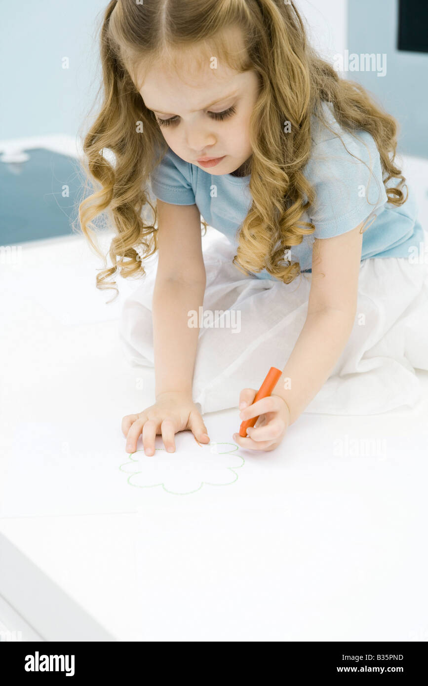 Little girl drawing with crayon, looking down Stock Photo - Alamy