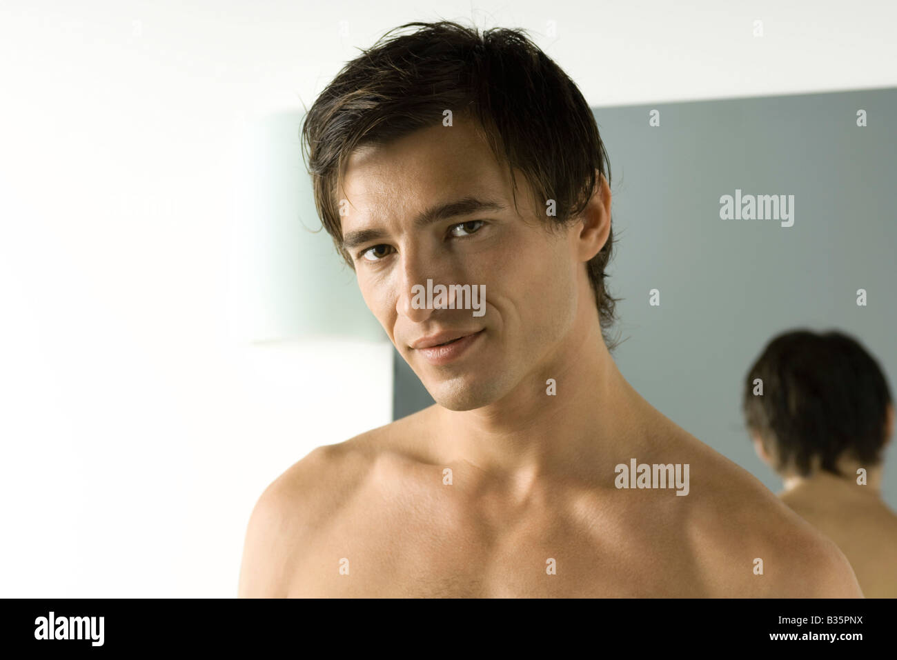 Bare-chested man smiling at camera, portrait Stock Photo