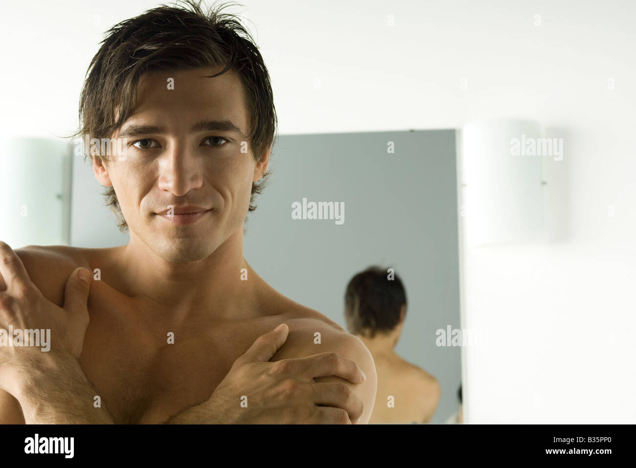 Man smiling at camera, arms folded across chest, portrait Stock Photo