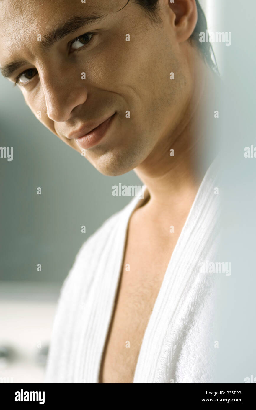 Man in bathrobe smiling seductively at camera, cropped Stock Photo