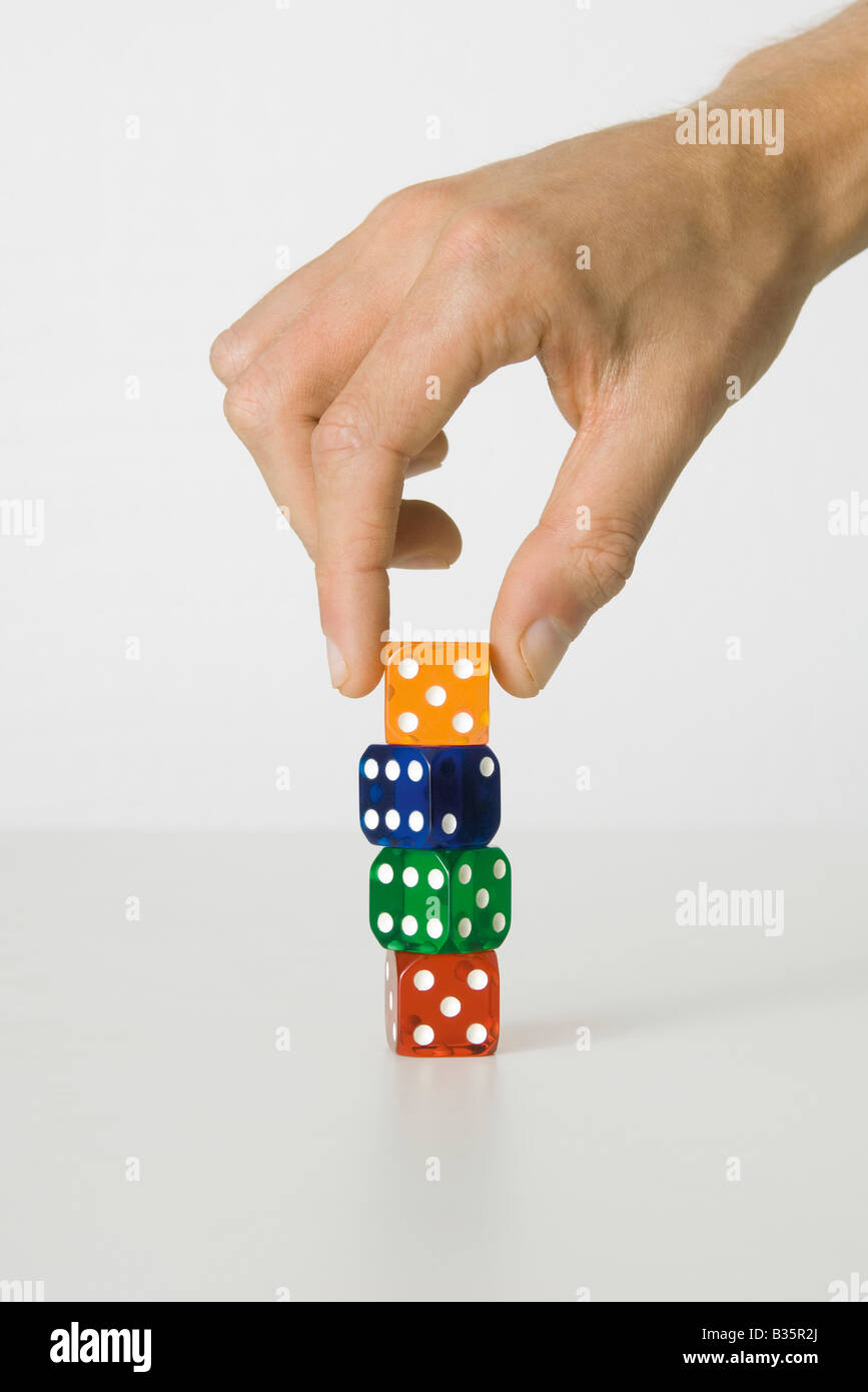 Hand stacking colorful dice, cropped view Stock Photo