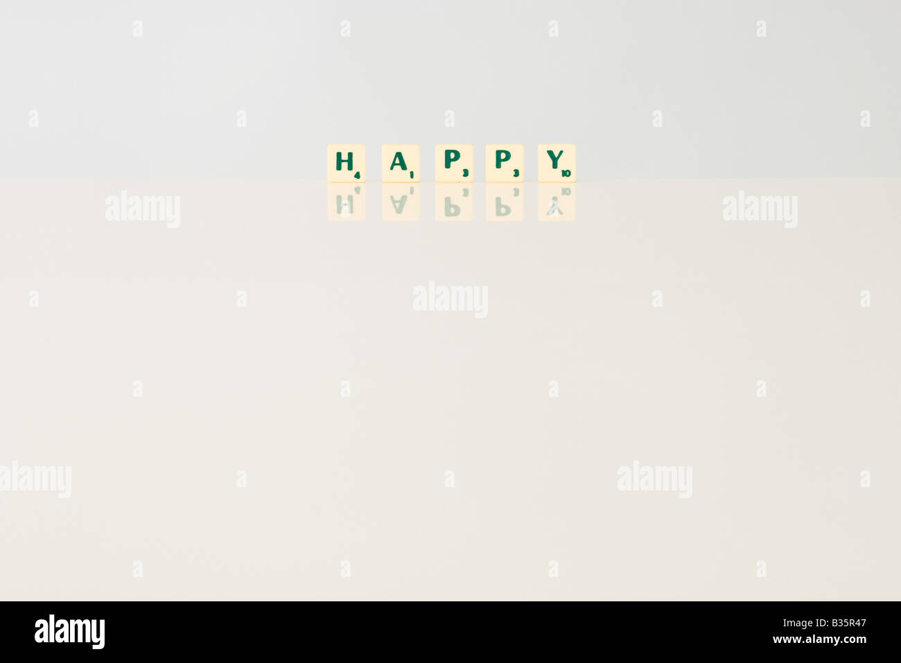 Word game tiles spelling the word 'happy' Stock Photo