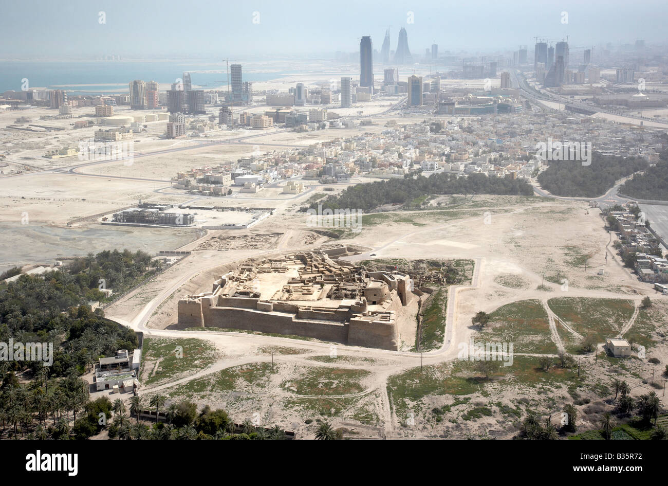 Aerial photo of Bahrain Fort also known as Portuguese Fort or Qal'at al-Bahrain with the skyline of Manama in the background. Stock Photo