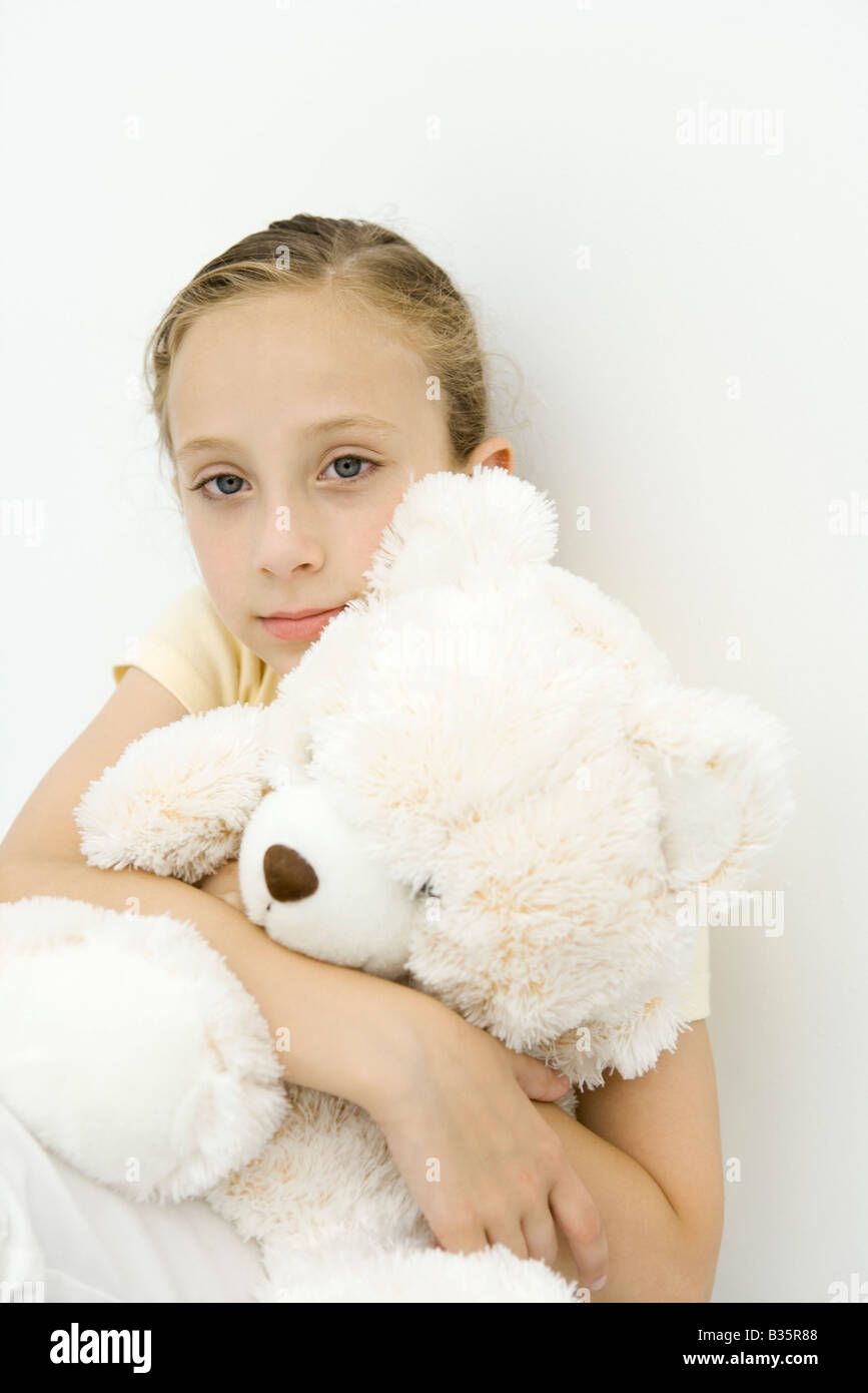 Girl holding teddy bear on her lap, looking at camera Stock Photo - Alamy