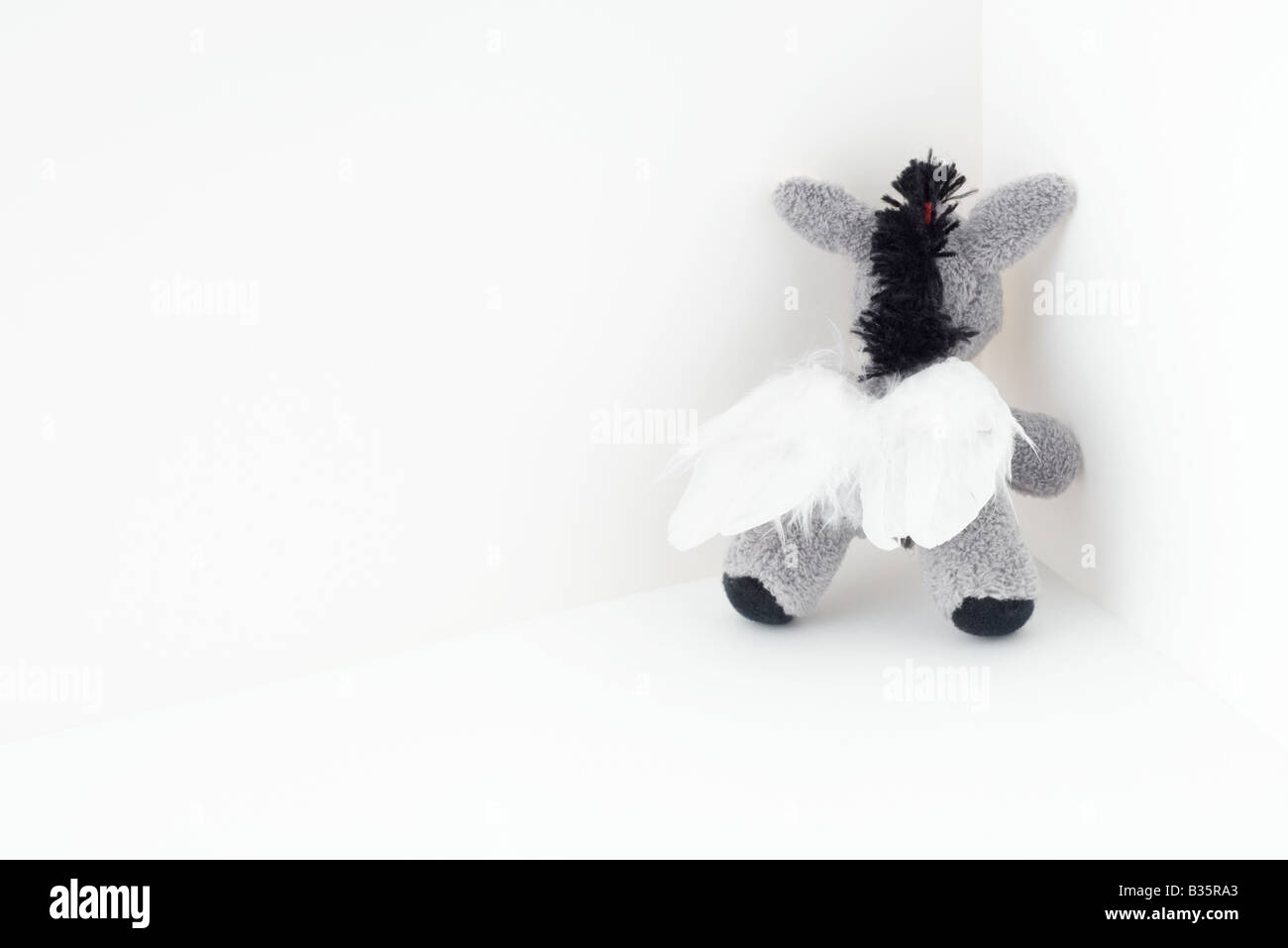 Stuffed elephant toy with wings, in the corner Stock Photo
