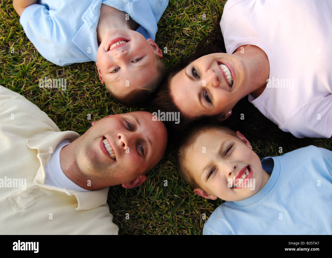 High angle view of a mid adult couple lying on grass in a circle with ...