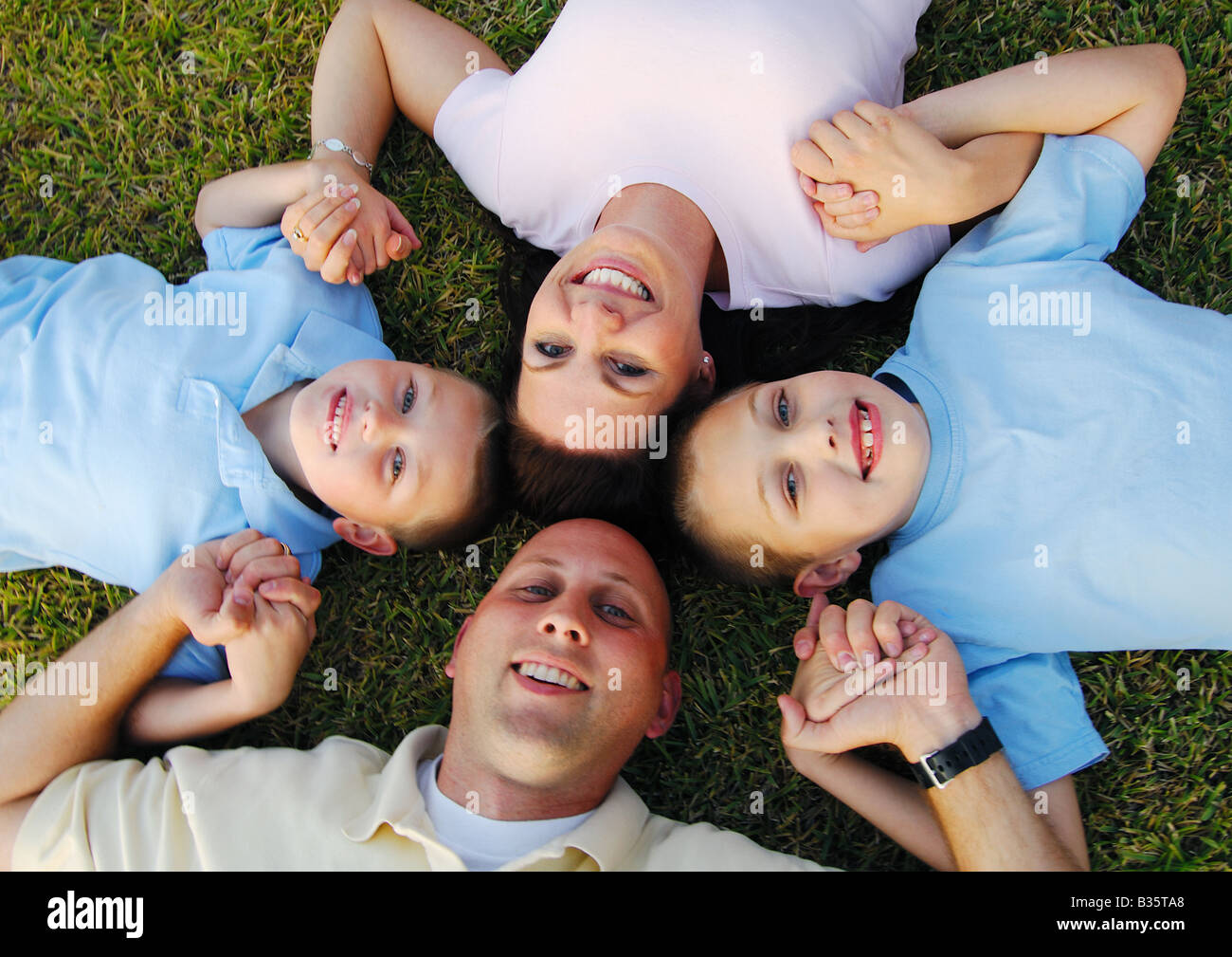 High angle view of a mid adult couple lying on grass in a circle with ...
