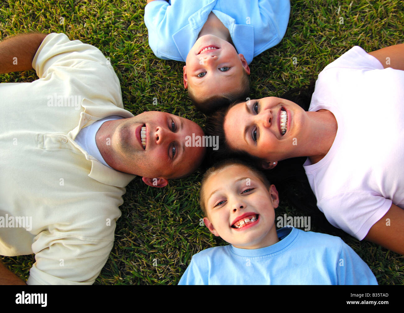 High angle view of a mid adult couple lying on grass in a circle with ...