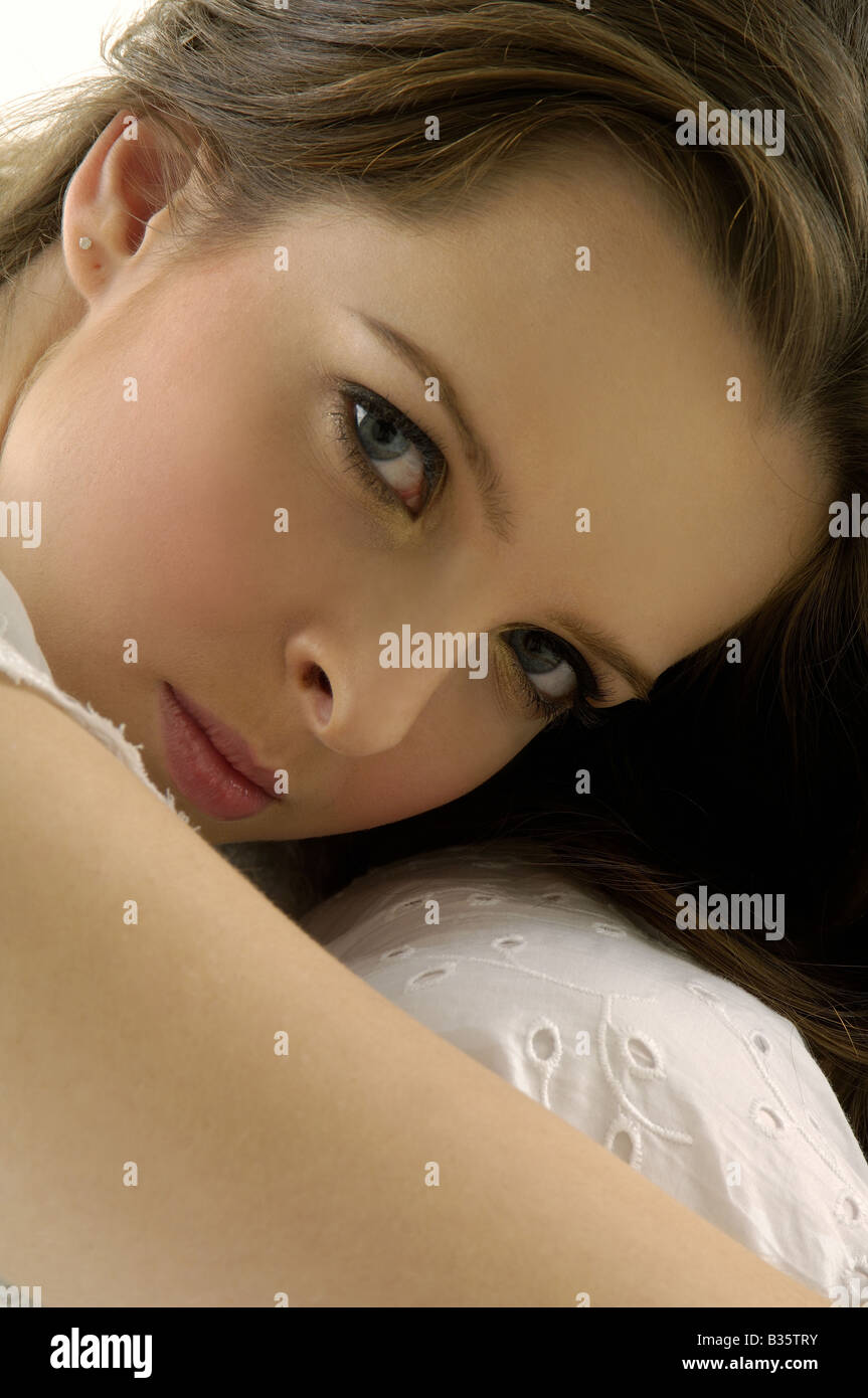 Portrait of a young woman hugging her knees Stock Photo - Alamy