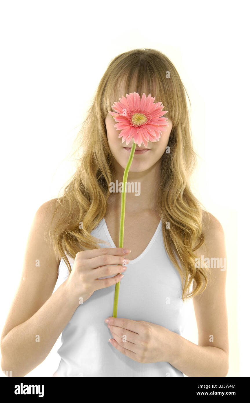 Close-up of a young woman holding a flower in front of her face Stock ...