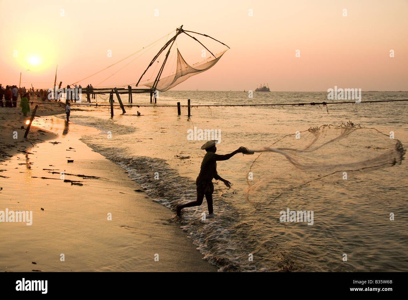 A fisherman casts his net close to the Chinese fishing nets of Fort Kochi  (Cochin) in Kerala, India Stock Photo - Alamy