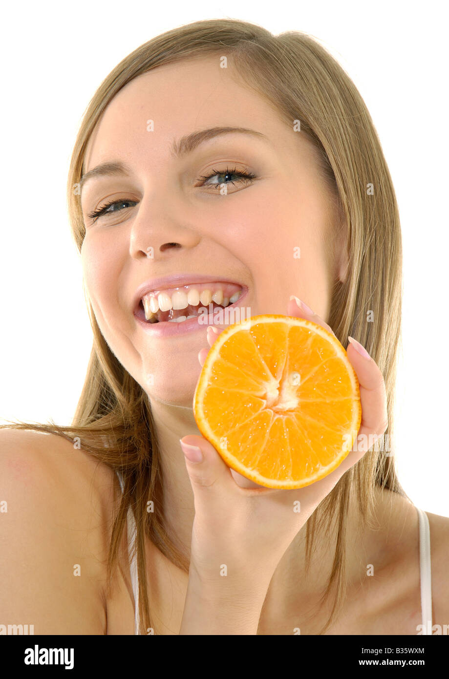 Portrait of a young woman holding a cross section of a orange and grining Stock Photo