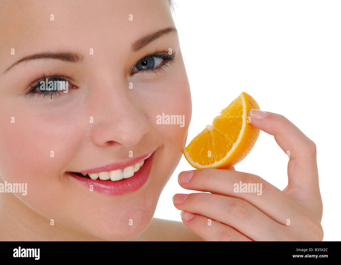 Portrait of a young woman holding a slice of orange Stock Photo - Alamy
