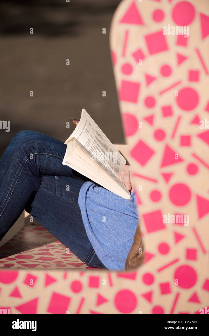 Young Girl relaxing and reading book Sloane Square Chelsea SW3 London United Kingdom Stock Photo