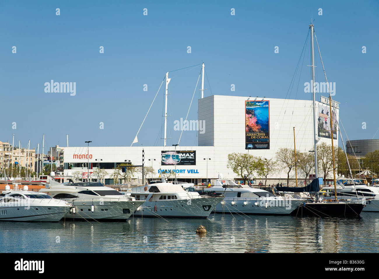 SPAIN Barcelona Sailboats docked in Marina Port Vell Maremagnum retail shopping and aquarium complex along waterfront Stock Photo