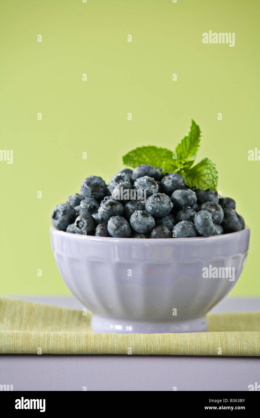 blueberries in bowl on green background Stock Photo