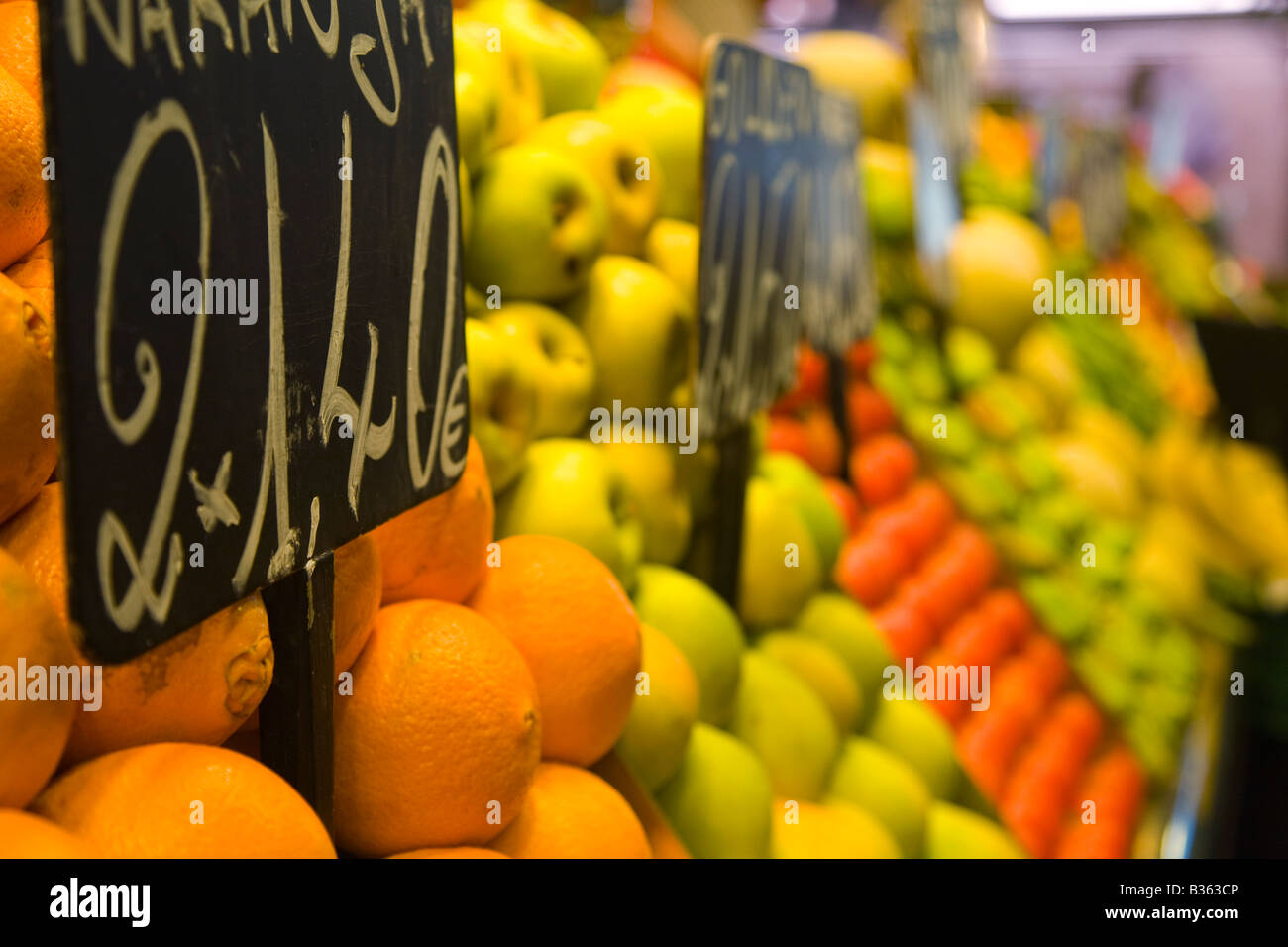 SPAIN Barcelona Piles of oranges apples and other fruit on display at La Boqueria produce market price sign in Euros Stock Photo