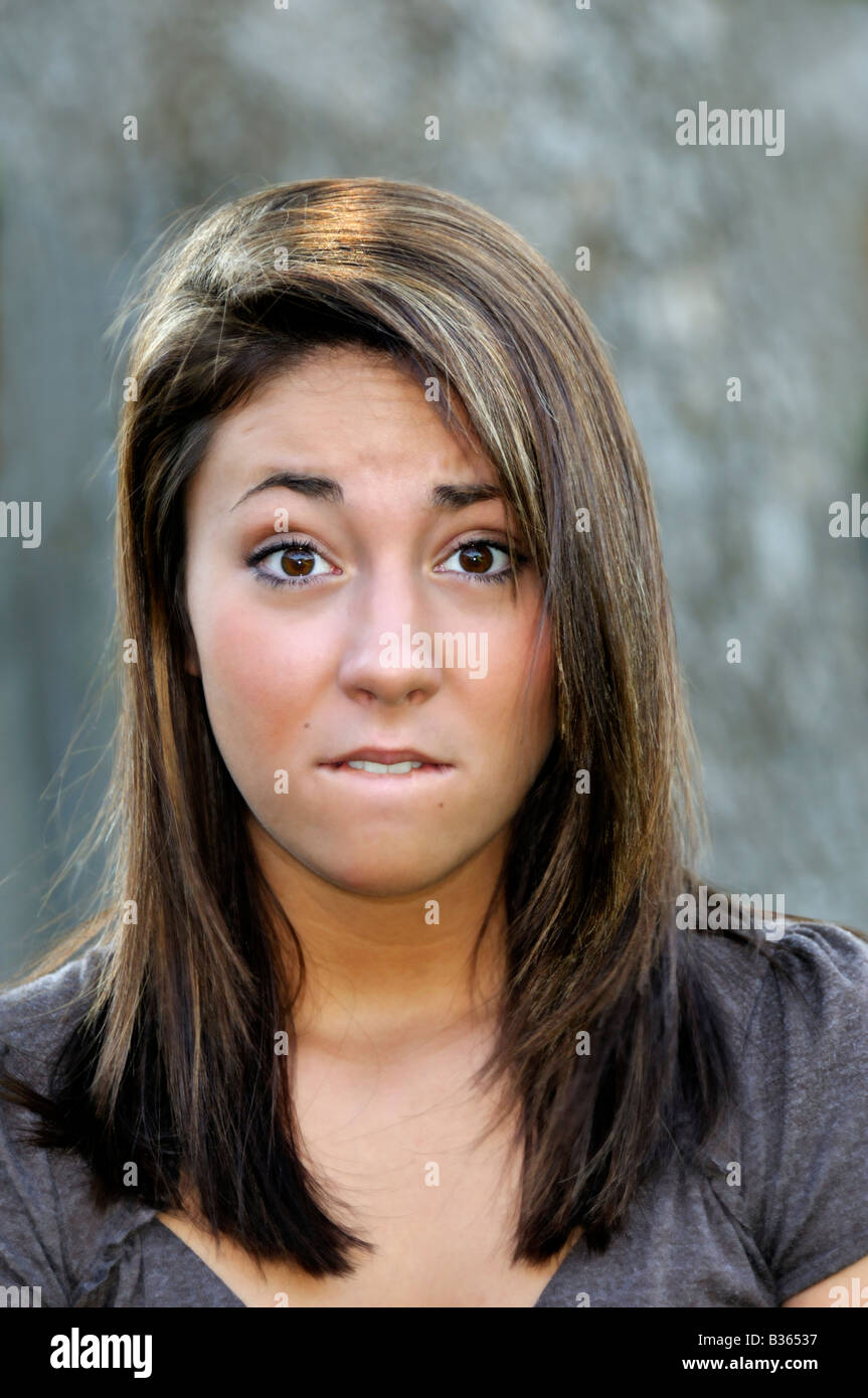 A pretty 16 year old girl has an expression of puzzlement or distress on her face. Stock Photo
