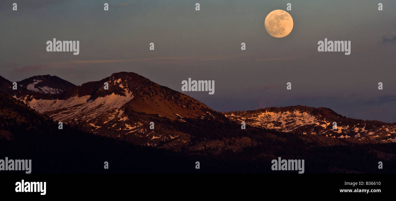 A full moon rises over the Ansel Adams Wilderness as seen from Sentinel Dome Yosemite National Park California USA Stock Photo