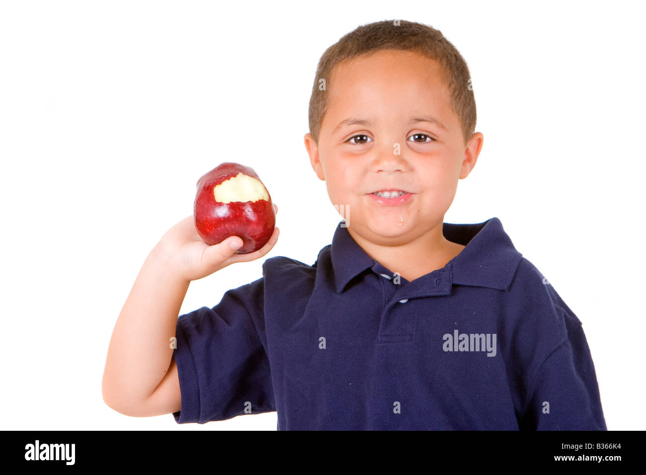 Young latino boy holding a bright red apple isolated against a white background Stock Photo