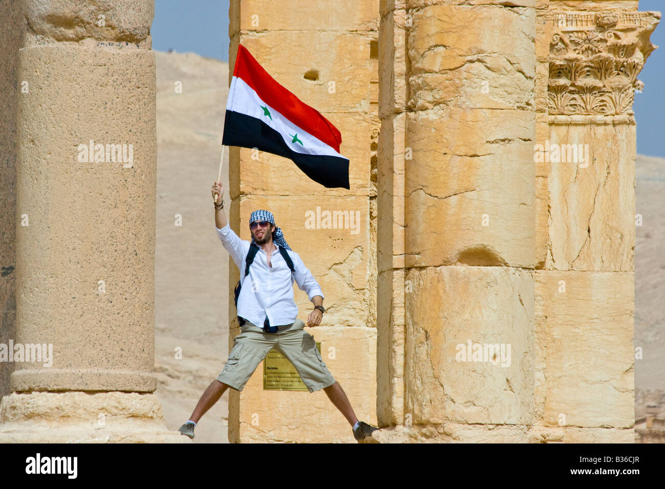 Tourist Waving a Syrian Flag at the Roman Ruins of Palmyra in Syria Stock Photo