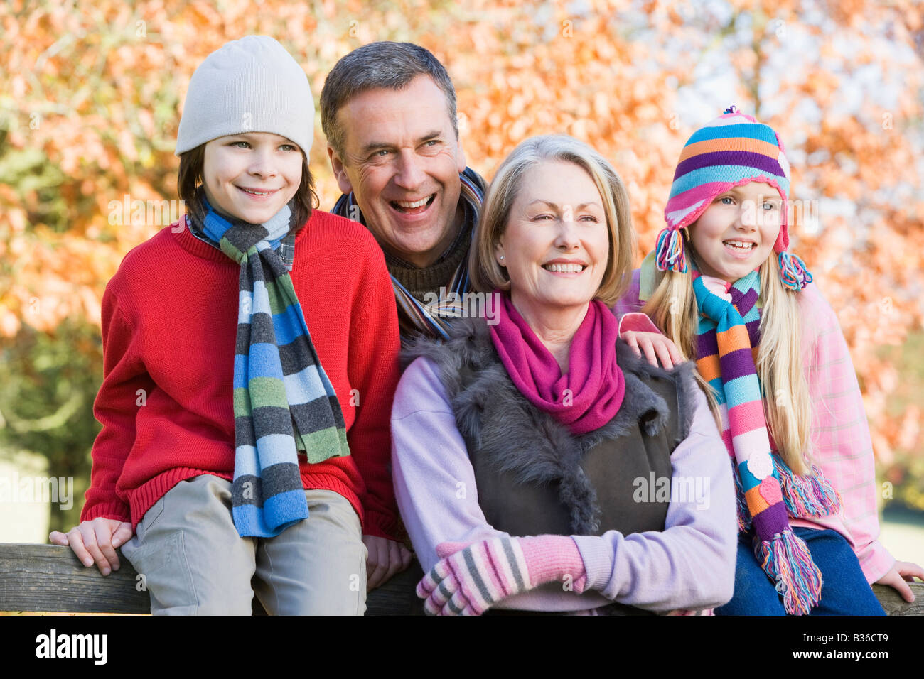 Grandparents with grandchildren outdoors at park smiling (selective focus) Stock Photo