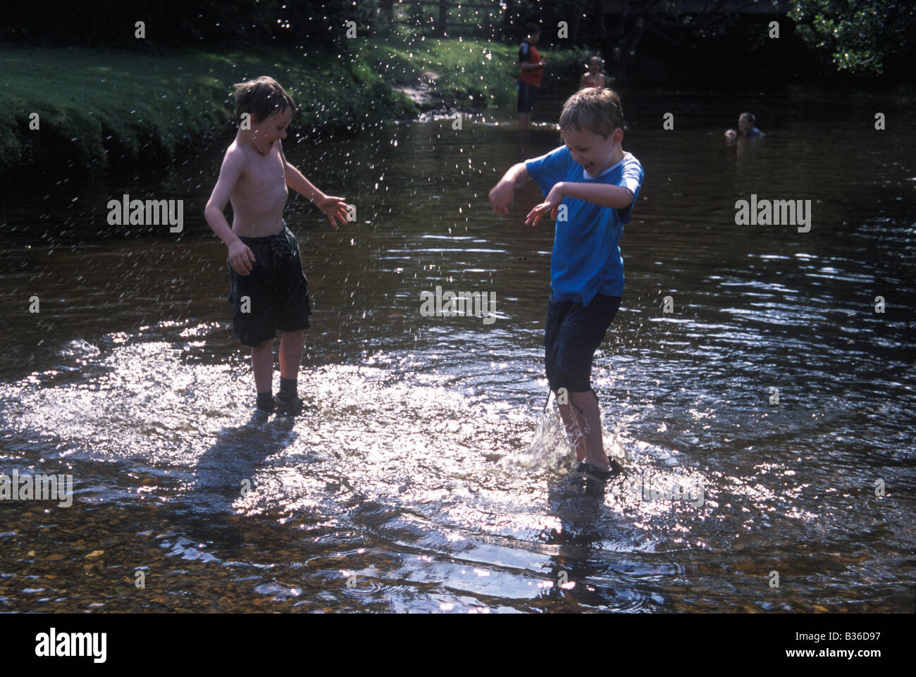 two boys splashing in the water Stock Photo - Alamy