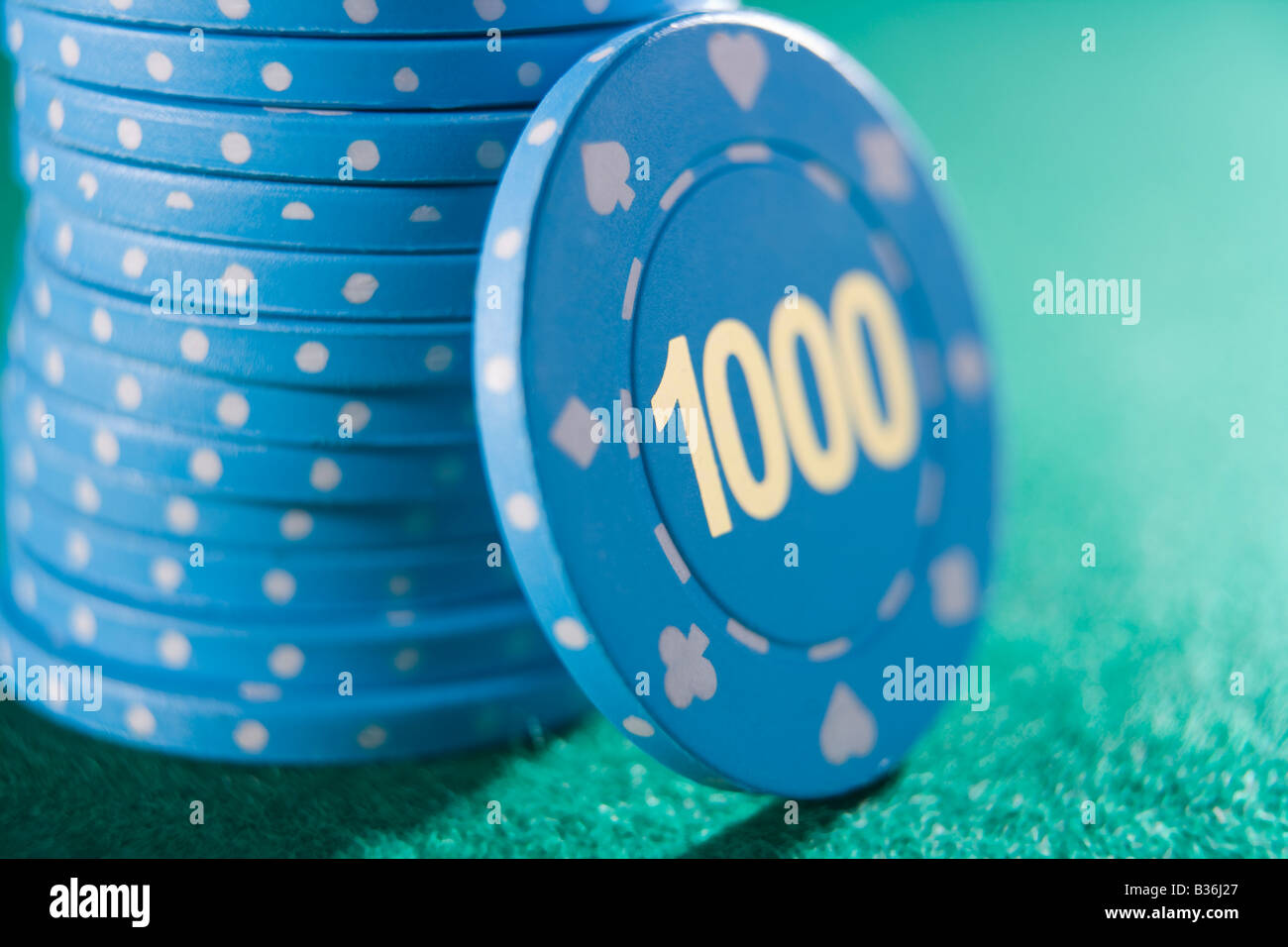 Poker chips piled on a poker table with one thousand chip showing (close up/selective focus) Stock Photo
