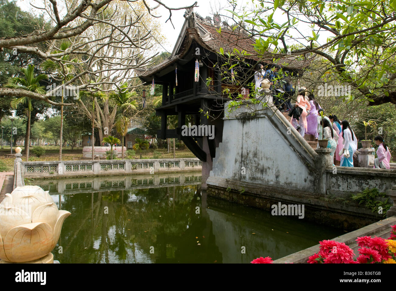 A crowd of Vietnamese woman dressed in traditional Ao Dai climb the steps of One pillar Pagoda in Hanoi Vietnam Stock Photo
