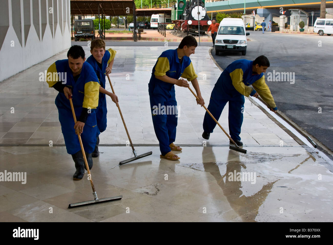 Young Syrian Men Cleaning the Sidewalk in Lattakia Syria Stock Photo
