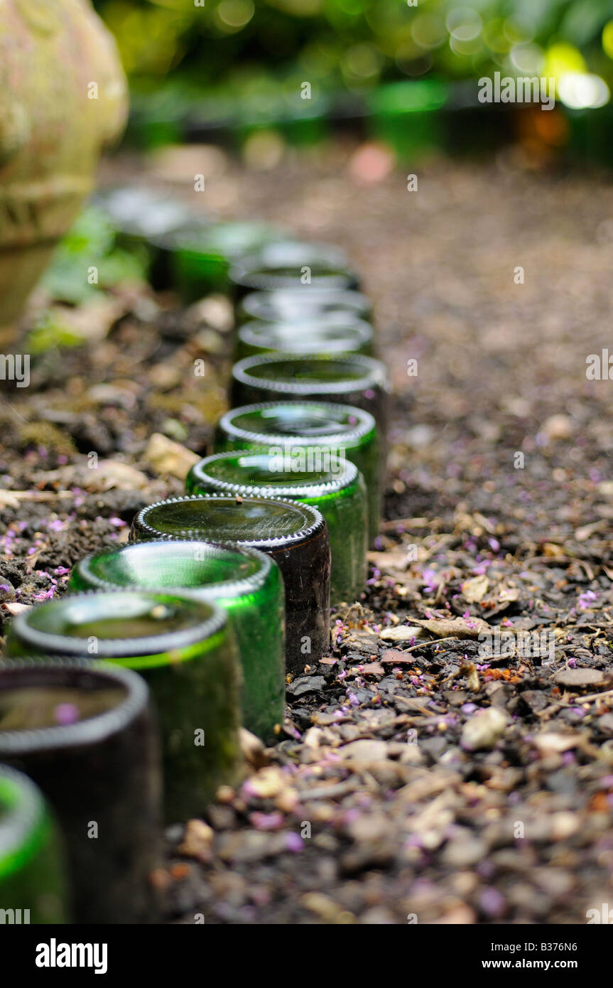 Bottles used as path edging feature in an urban garden Norfolk UK Stock Photo