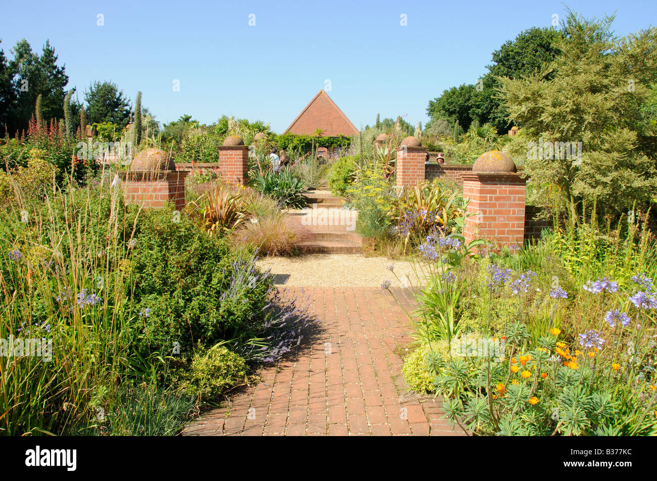 Path with ornamental brick plinths leading to brick summerhouse in large garden East Ruston Norfolk Uk July Stock Photo