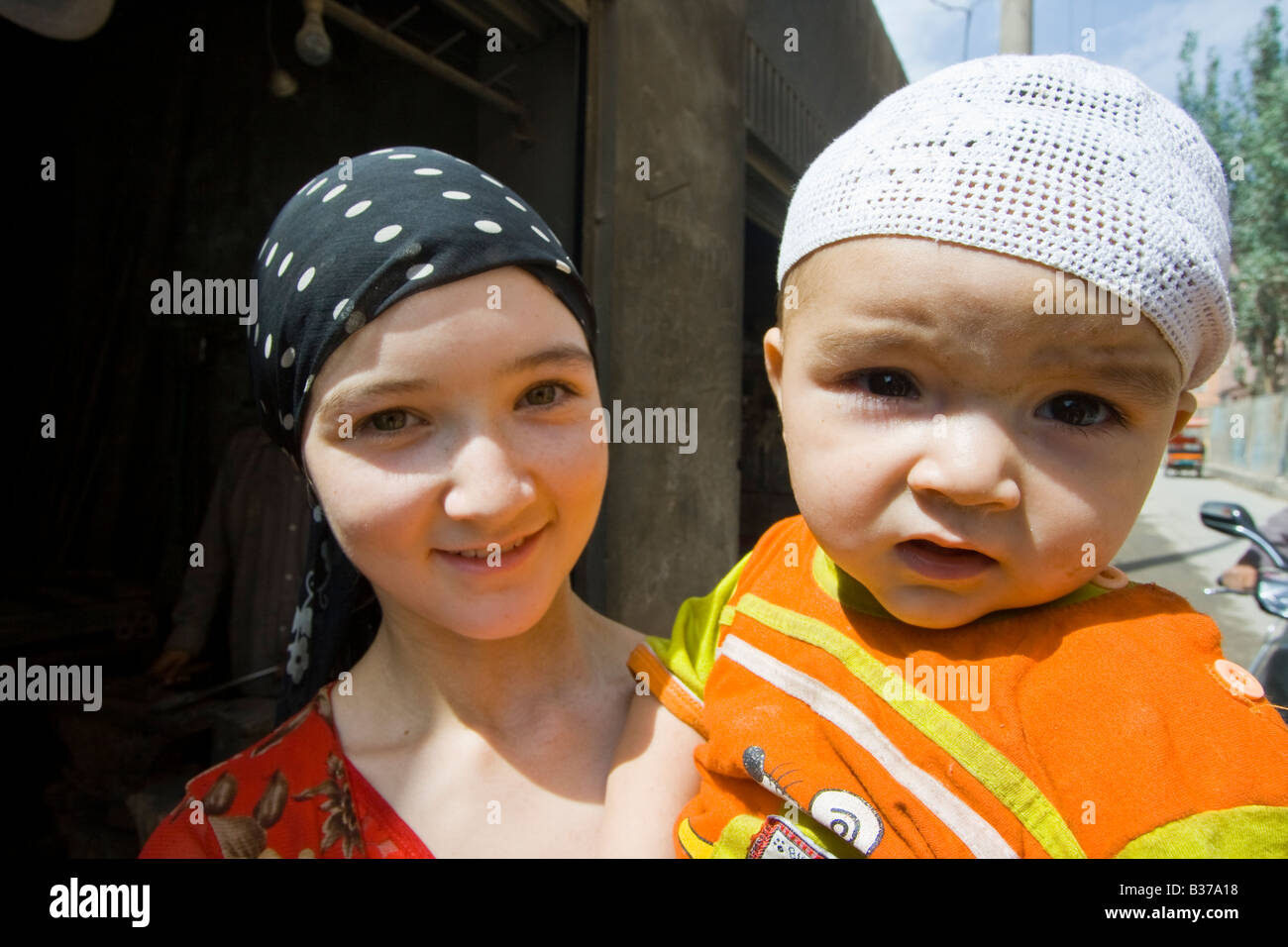 Muslim Uyghur Girl and Baby in Yarkand in Xinjiang Province China Stock Photo
