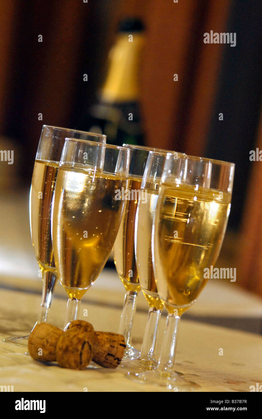 Four glasses filled with chilled champagne at a summer wedding