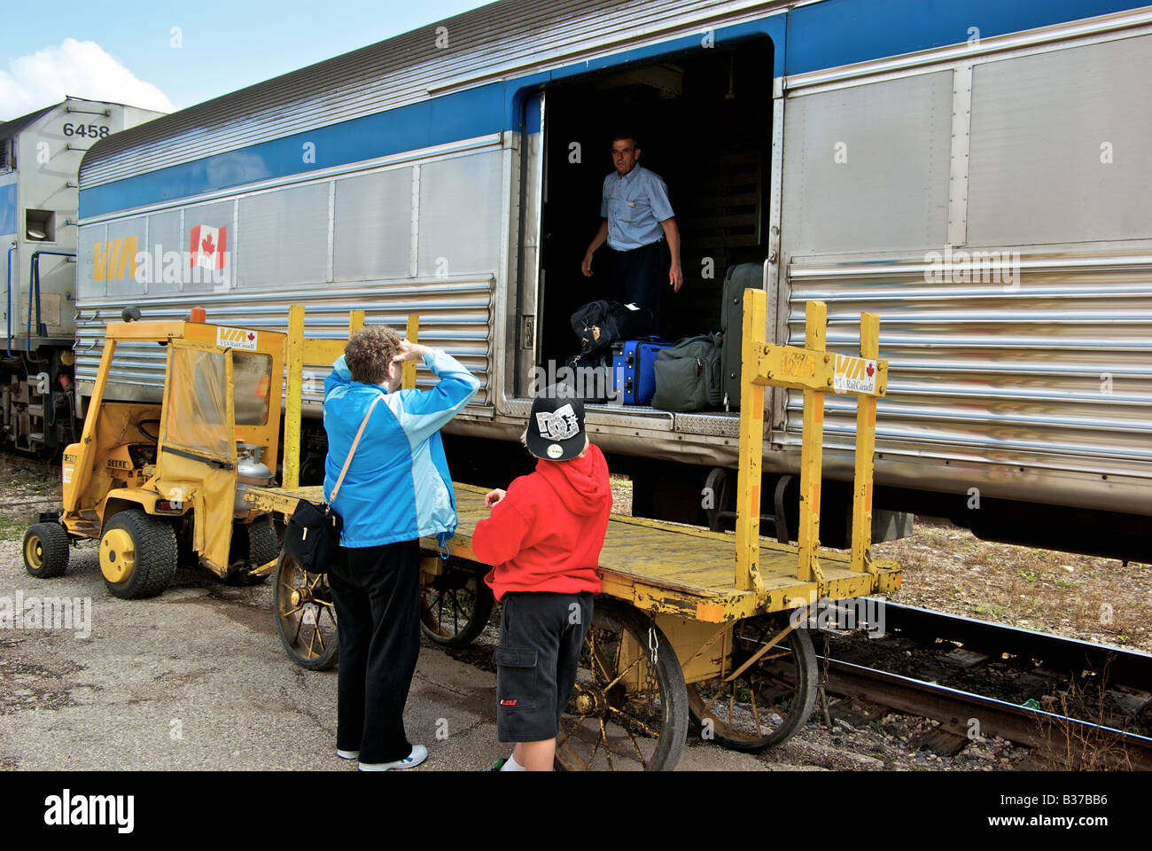 Passengers getting baggage from that baggage car at a railway station