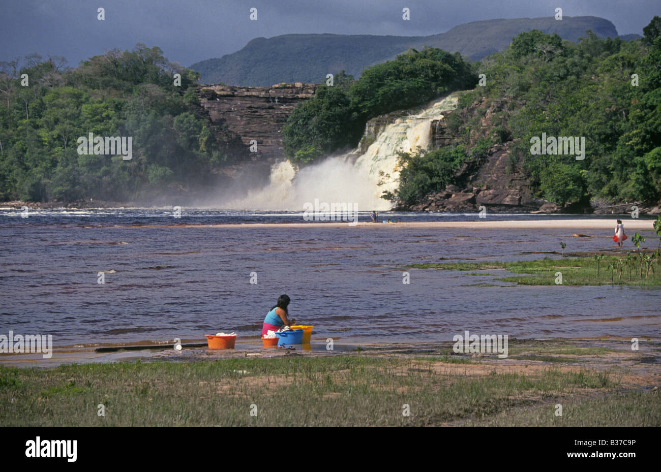 An Pemon Indian woman washes clothes in the Caroni River in Canaima National park in the Gran Sabana region in Bolivar State in Venezuela Stock Photo