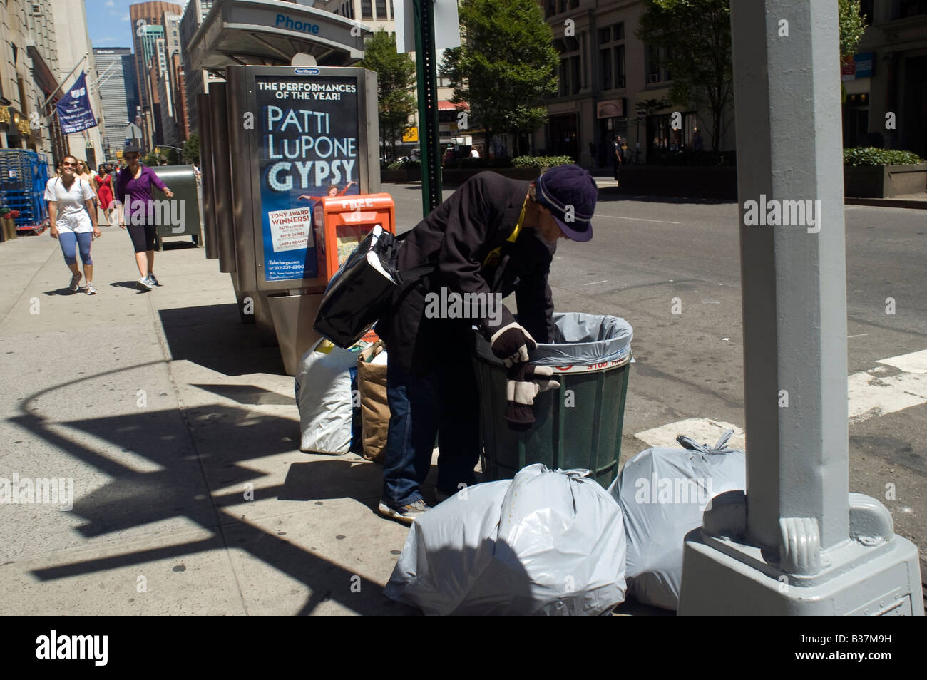 a-homeless-man-goes-through-a-trash-can-midtown-manhattan-in-new-york-B37M9H.jpg