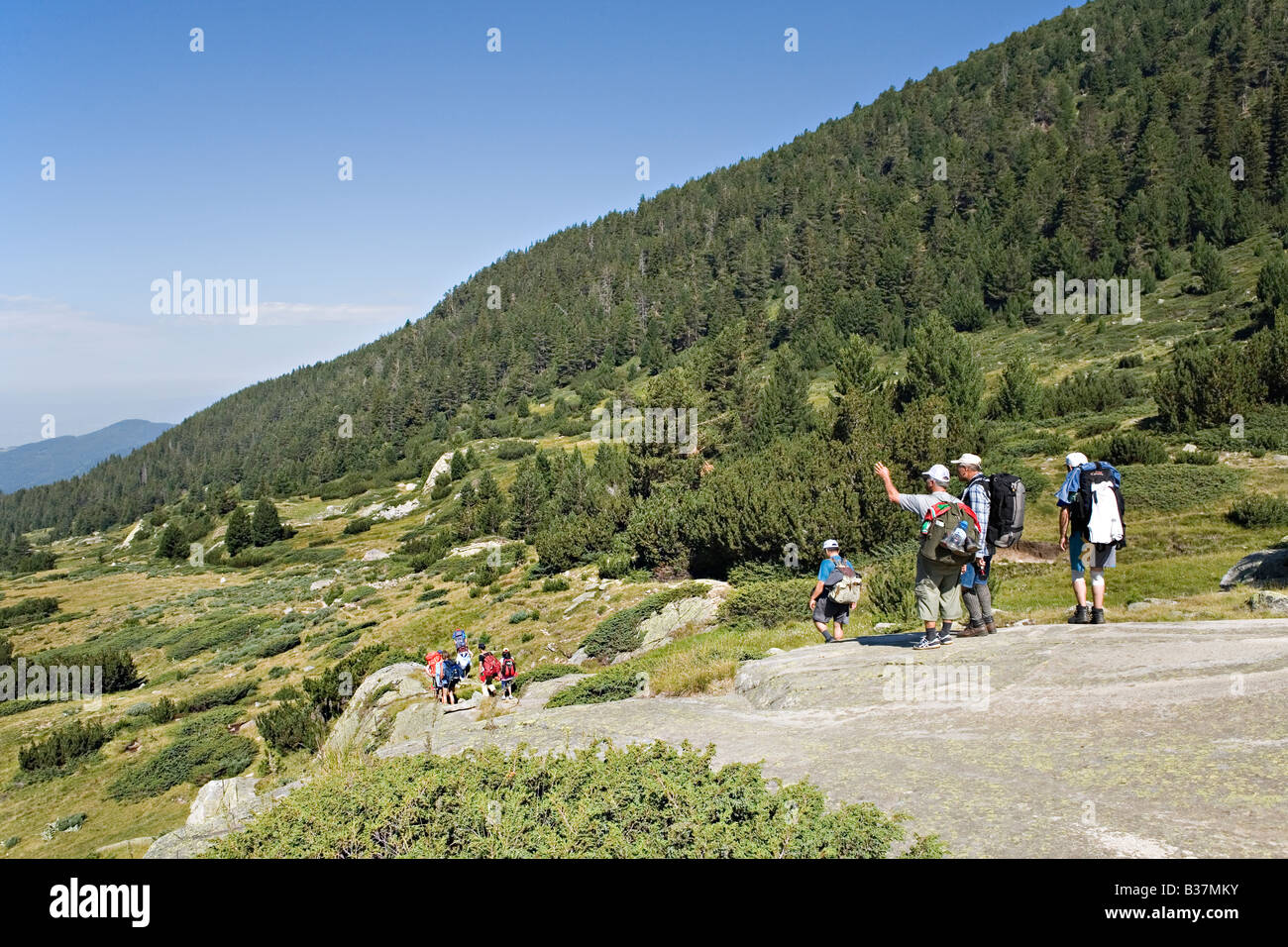 People walking in Kozi river valley in World Heritage Site Pirin National Park Bulgaria Stock Photo