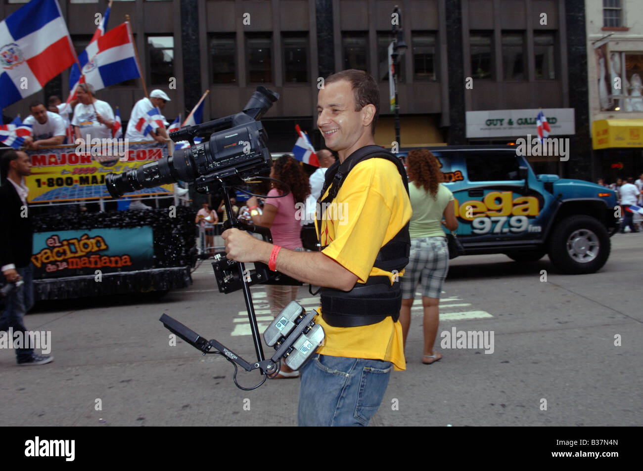 Camera operator uses a Steadicam at the annual Dominican Independence Day Parade in NYC on Sixth Avenue on August 10 2008 Stock Photo