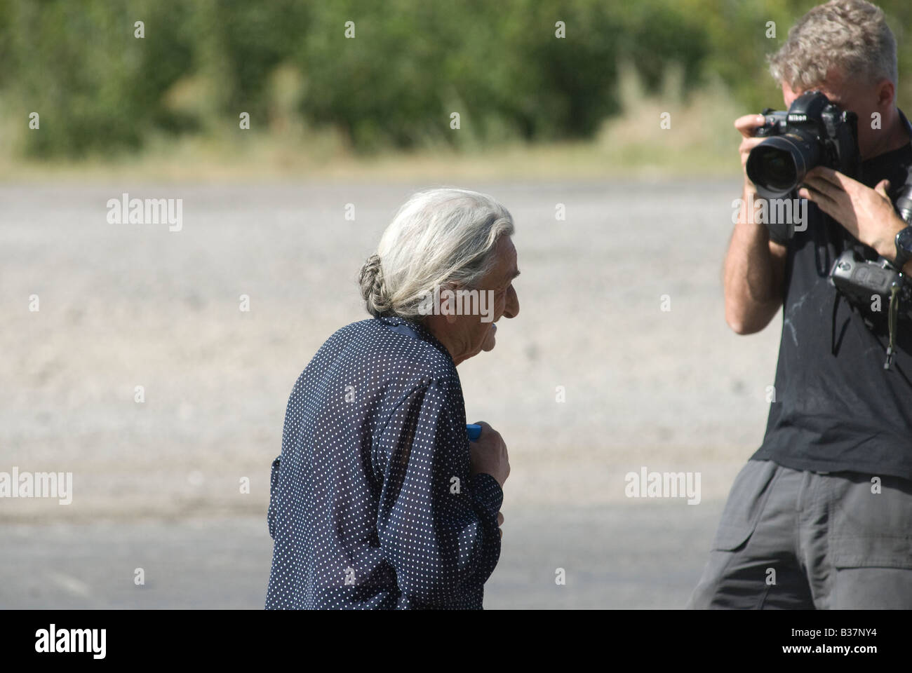 A Photojournalist takes a photo of an elderly Georgian civilian fleeing the city of Gori, during the Russo-Georgian War August 2008 Stock Photo