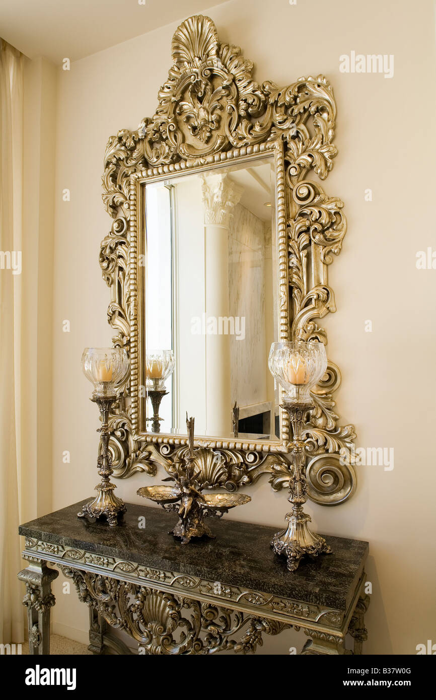 Detail of a decorative mirror above a small side table Stock Photo - Alamy