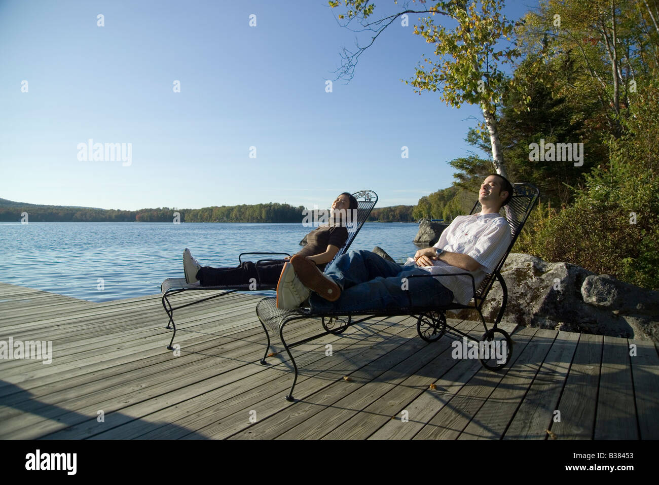 Man and Woman relaxing at lakeside Stock Photo
