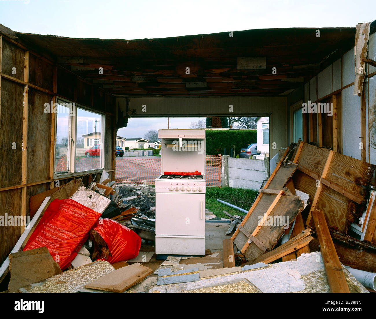 Wooden house being demolished with scrap cooker Stock Photo - Alamy