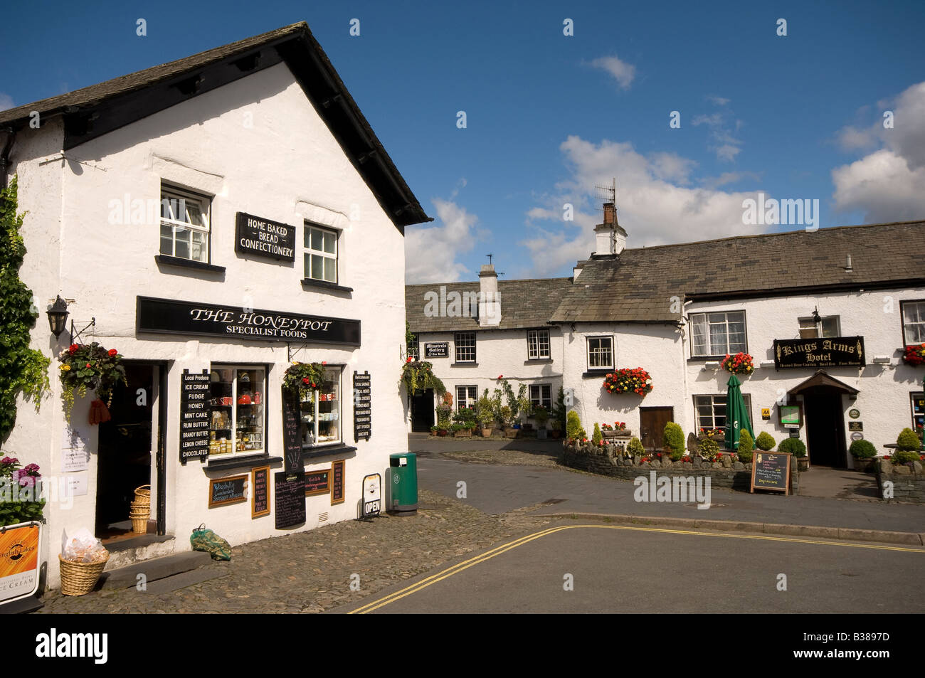 Shops pub and white washed cottages Hawkshead Village street in summer The Lake District Cumbria England GB Great Britain UK United Kingdom Stock Photo