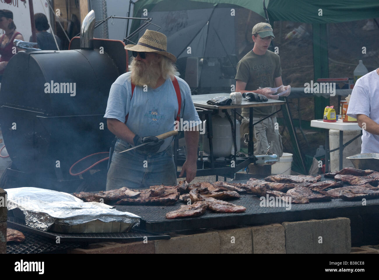 Man cooking a large amount of ribs at a local festival. Stock Photo