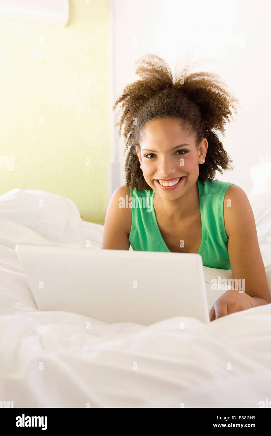 African woman with laptop on bed Stock Photo - Alamy