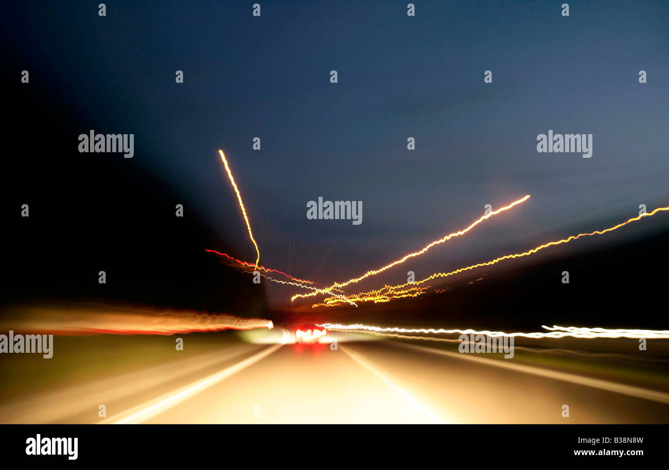Night driving shot from car point of view with streaks of car lights and motion blur Stock Photo