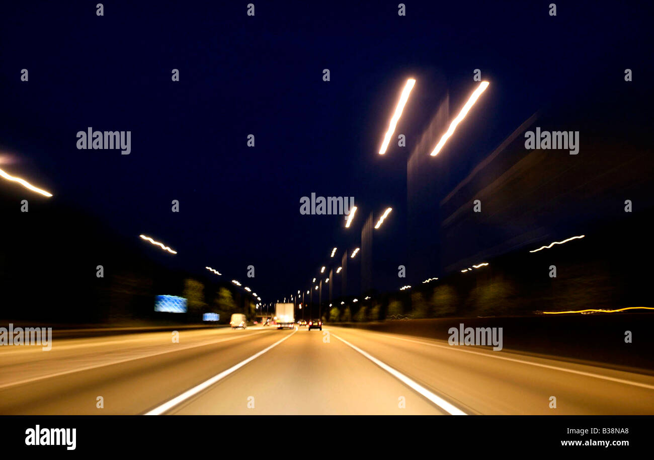Night driving shot from car point of view with streaks of car lights and motion blur Stock Photo