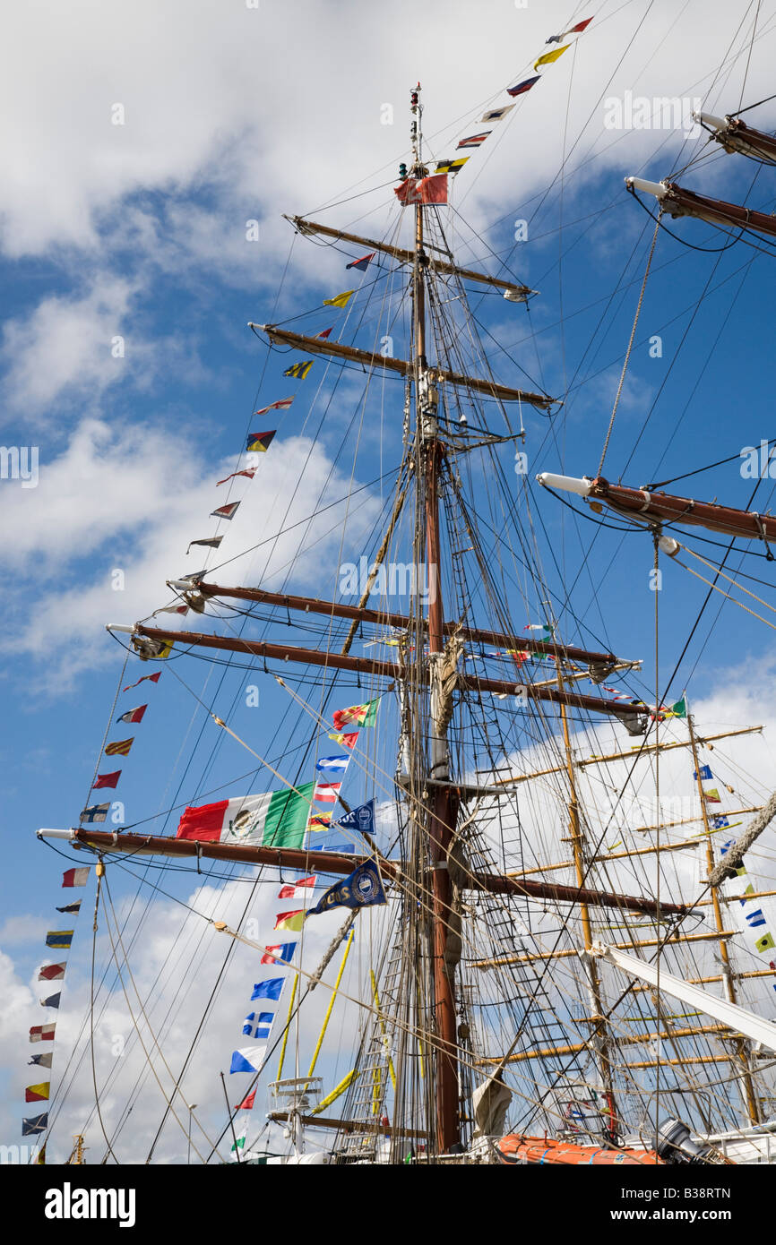 Square rigged masts flying colourful flags on boats in Tall Ships race